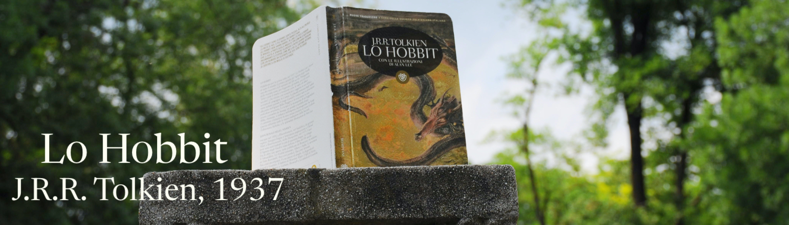 il libro è poggiato sopra una colonna di pietra, sull'immagine si trova il titolo del libro, ovvero Lo Hobbit, edito nel 1937 e scritto da J.R.R. Tolkien