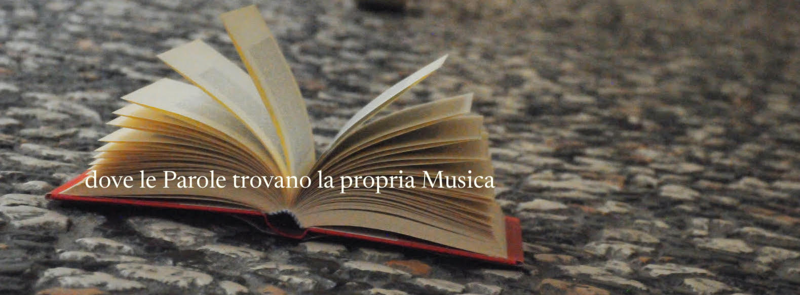 un libro aperto a metà, poggiato su una strada in pietra, su cui si legge il pay-off del sito, 'dove le parole trovano la propria musica'